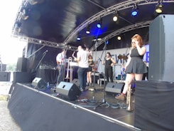 Live band playing soulful music on an outdoor stage with festival crowd.