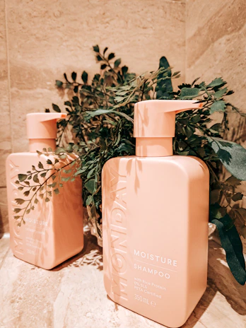 A sleek bottle of Ymora shampoo on a bathroom shelf with soft morning light.
