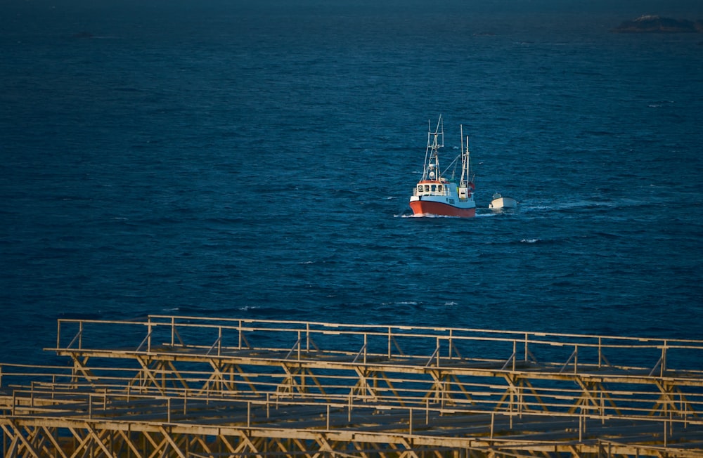 a red and white boat in the middle of the ocean