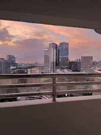 View from the luxury room balcony overlooking the city skyline at sunset.