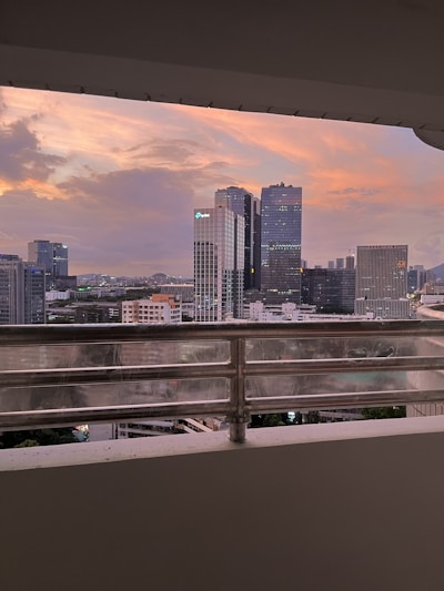 A sleek modern condo balcony overlooking Cebu City's skyline bathed in golden sunset light.