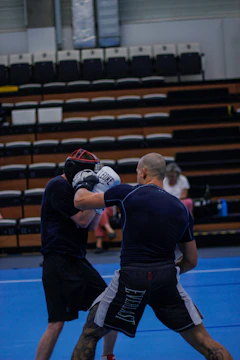 Energetic kids sparring in pairs on wrestling mats inside the club’s training hall.
