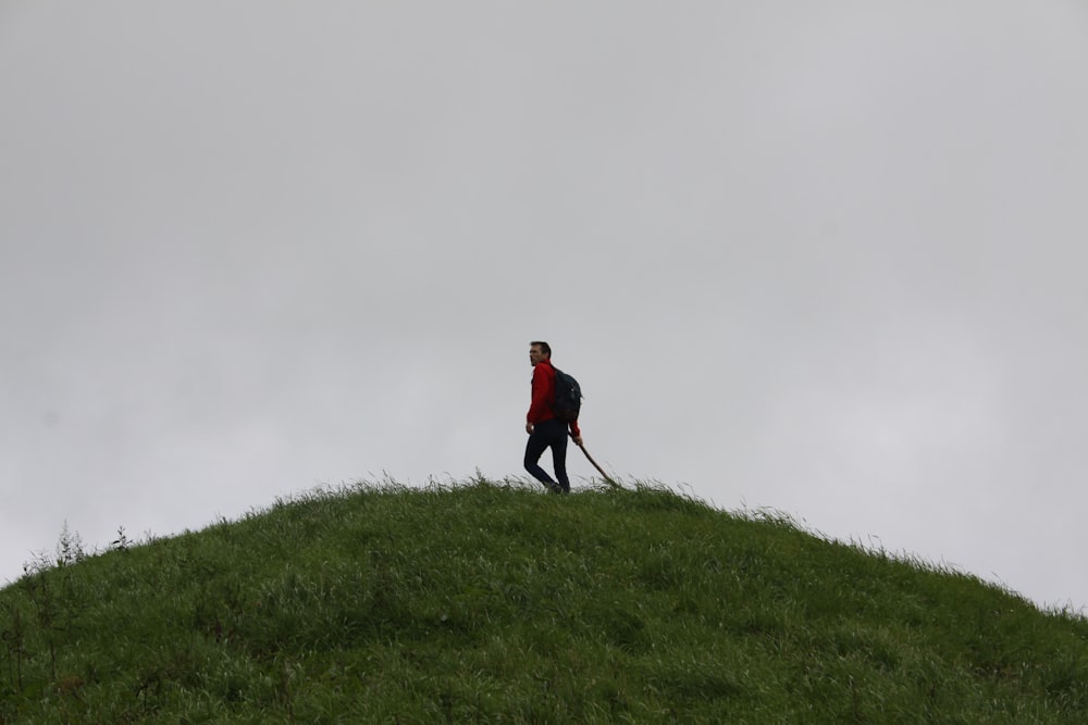 a man standing on top of a lush green hillside