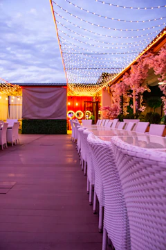Elegant outdoor restaurant seating with polypropylene chairs and fiberglass tables under warm lighting.