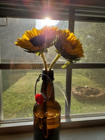 Serotoskin bottle resting on a sunlit windowsill surrounded by fresh flowers.