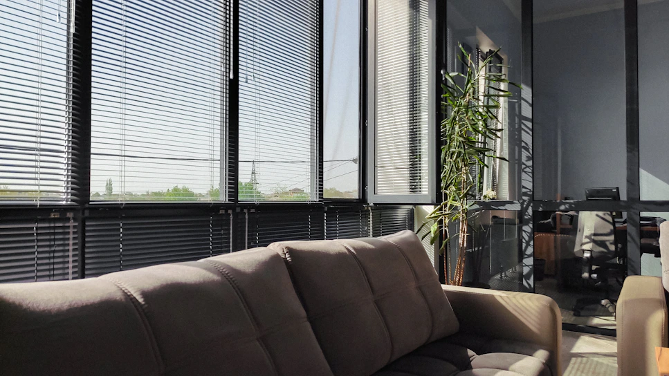 A cozy living room with sleek blinds filtering soft natural light.