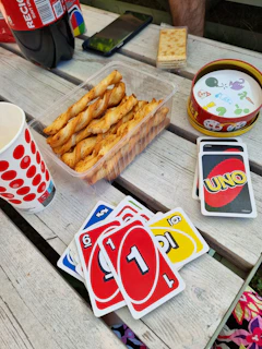 Flat lay of the 'pizza chat' game cards spread out on a rustic wooden table.