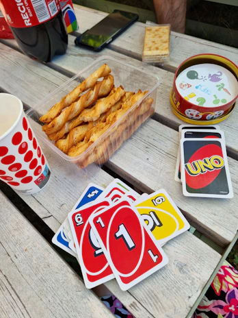 Flat lay of the 'pizza chat' game cards spread out on a rustic wooden table.