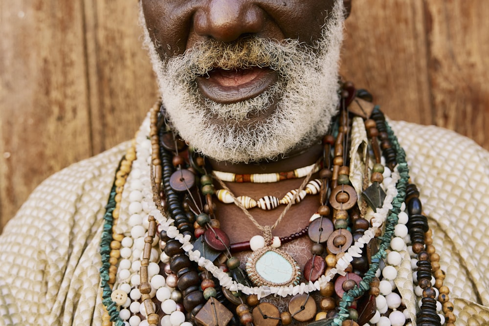 a man with a beard wearing a variety of necklaces