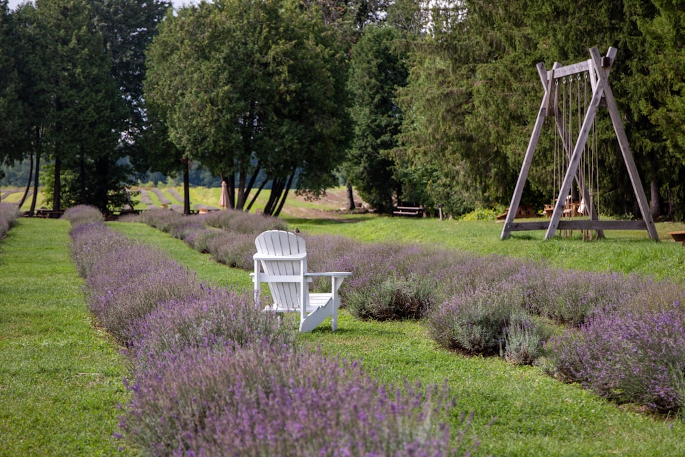 a white chair sitting on top of a lush green field