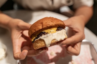 Artistic shot of a perfectly grilled steak burger with mustard sauce dripping slightly.