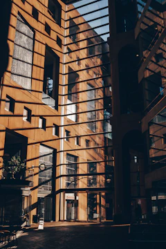 A sleek, modern luxury home bathed in warm, earthy light with subtle shadows highlighting its architectural details.