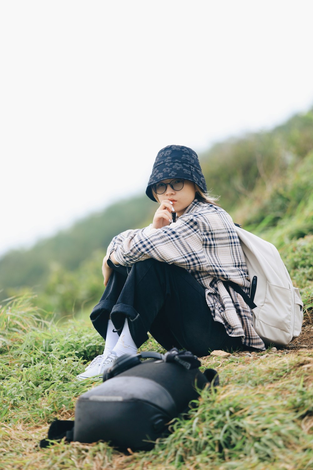 a person sitting on the ground with a backpack