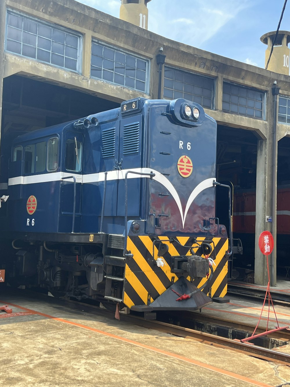 a blue train parked in front of a train station