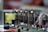 Four vacuum tubes are mounted on a circuit board with various electronic components, including wires, resistors, and connectors. The background is blurred, highlighting the tubes as the central element.