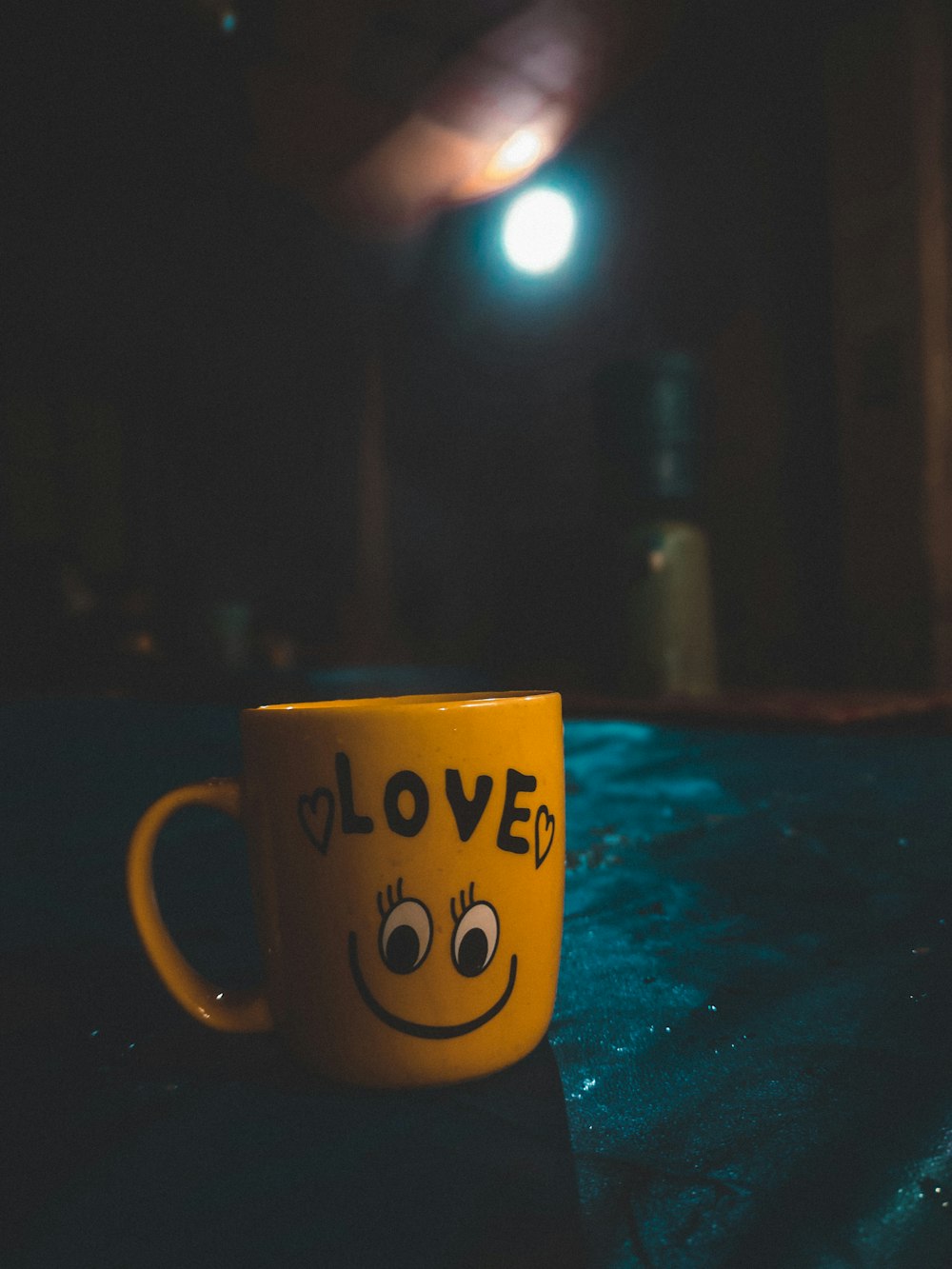 una tazza di caffè giallo con una faccina sorridente disegnata su di essa