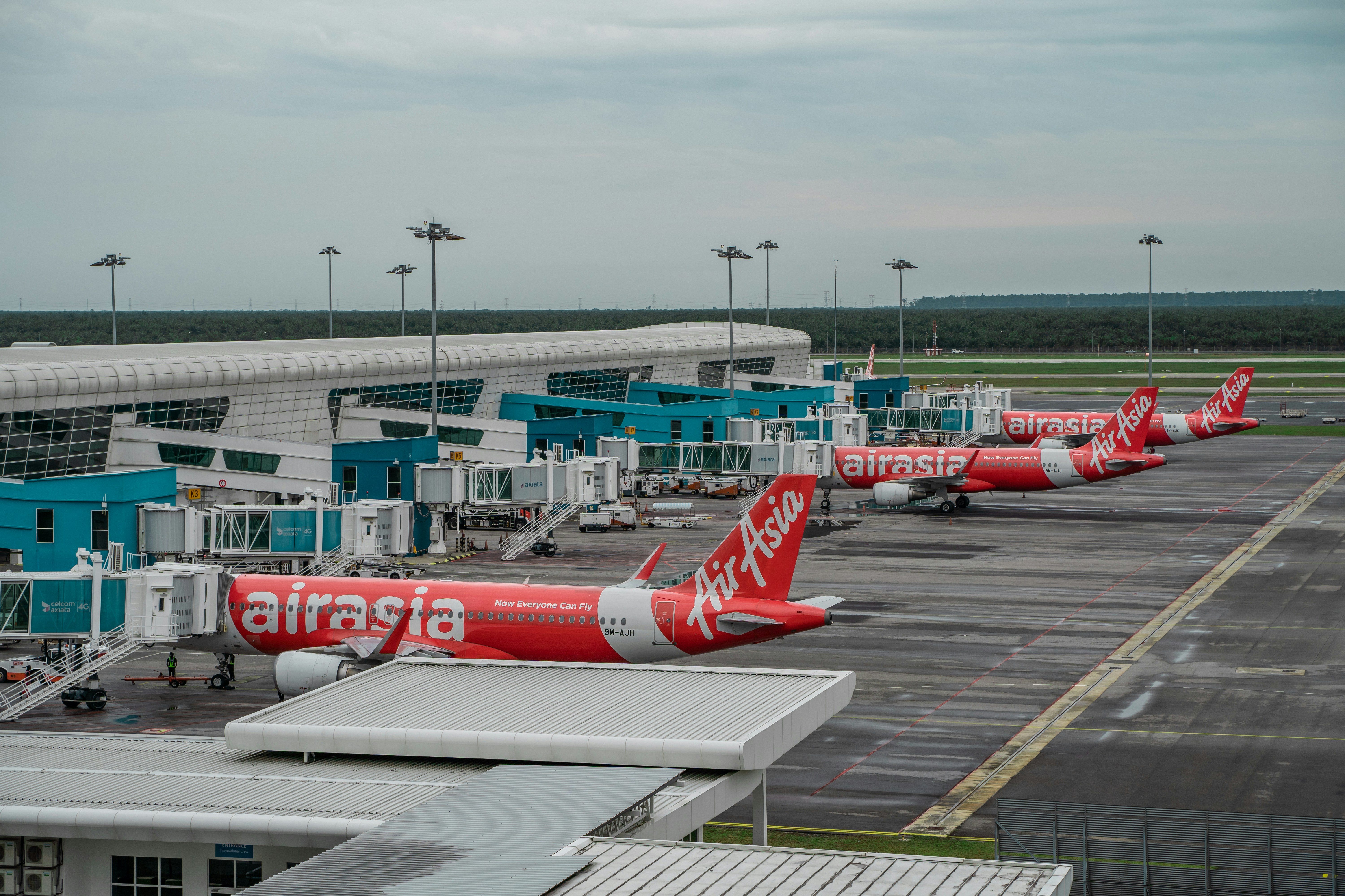 a row of red and white airplanes parked at an airport