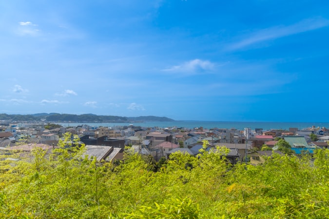 Japanese seaside coastal town with traditional rooftops overlooking the ocean under a cloudy sky