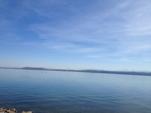 A serene lake view with mountains in the background under a clear sky.