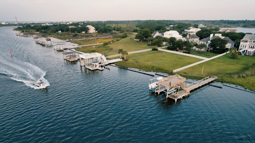 a boat traveling down a body of water next to houses