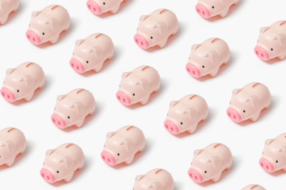 a group of small pink pig figurines on a white surface