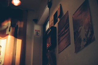 A cozy corner with framed posters and soft lighting highlighting textures.