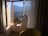 Man relaxing by a hotel room window with a scenic view.