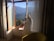 Man relaxing by a hotel room window with a scenic view.