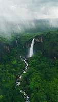 a waterfall in the middle of a lush green forest