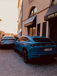a blue sports car parked in front of a hotel