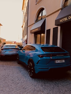 a blue sports car parked in front of a hotel