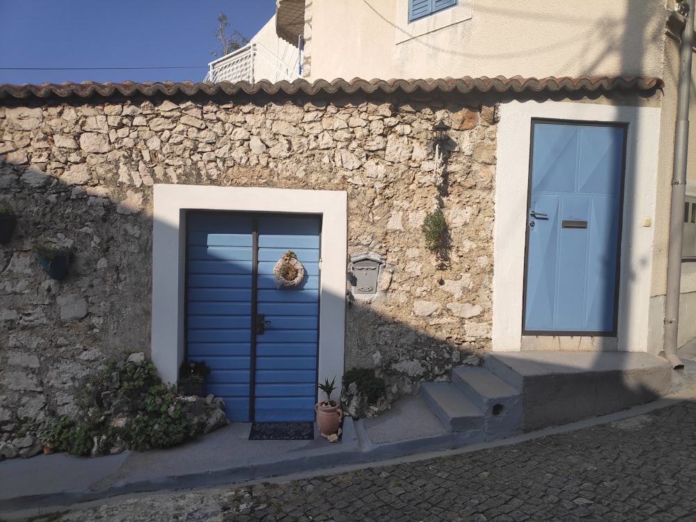 a stone building with a blue door and steps