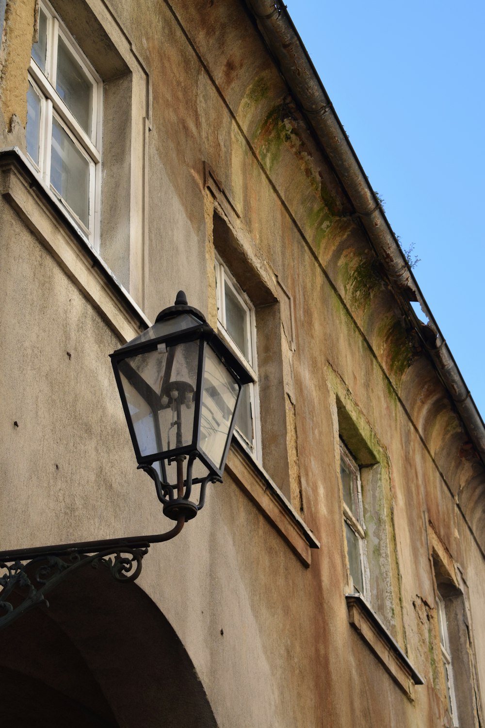 an old fashioned street light on the side of a building