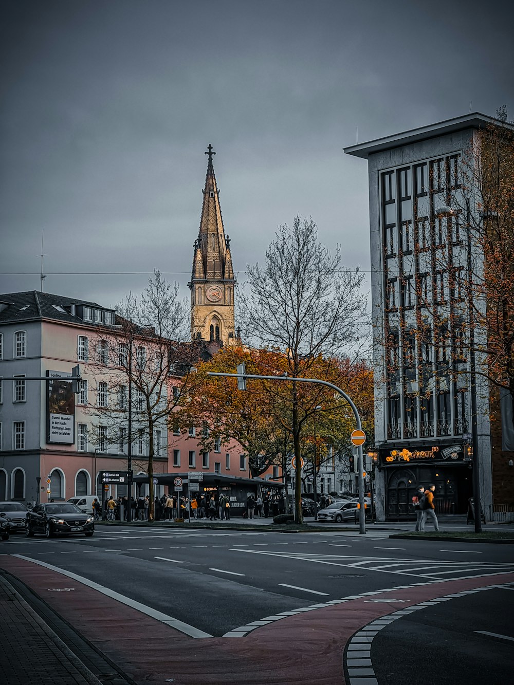 a city street with a church steeple in the background