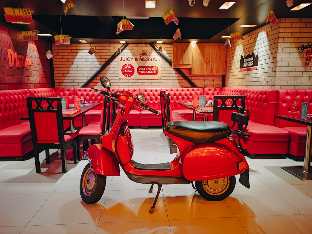 a red scooter is parked in a restaurant