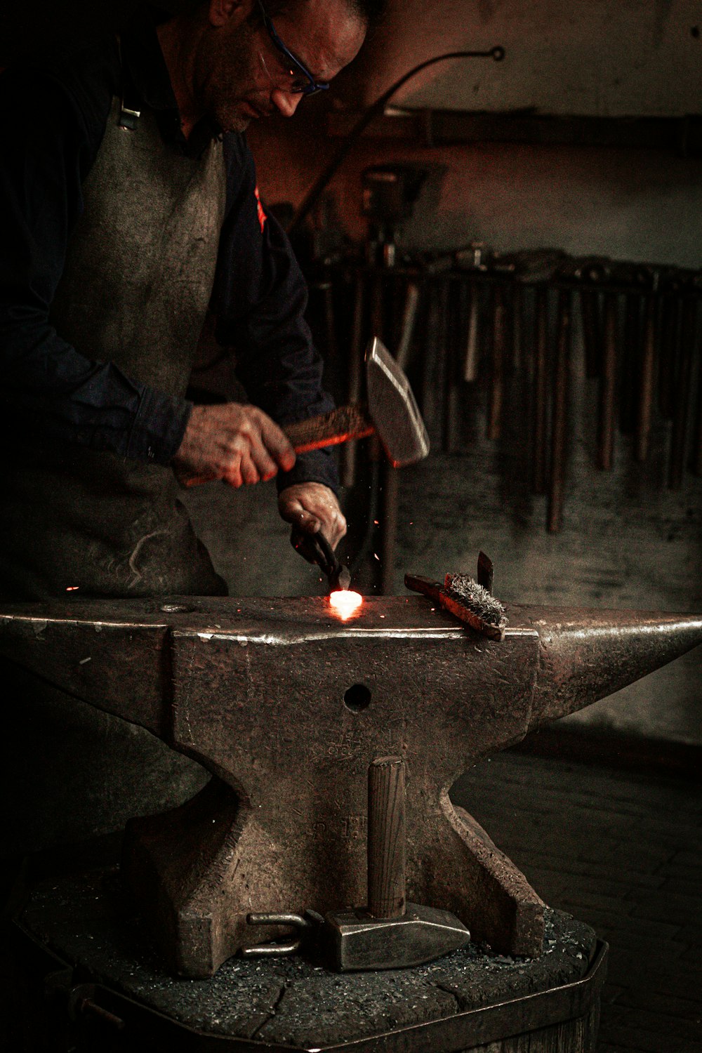 a man working on a piece of metal with a hammer