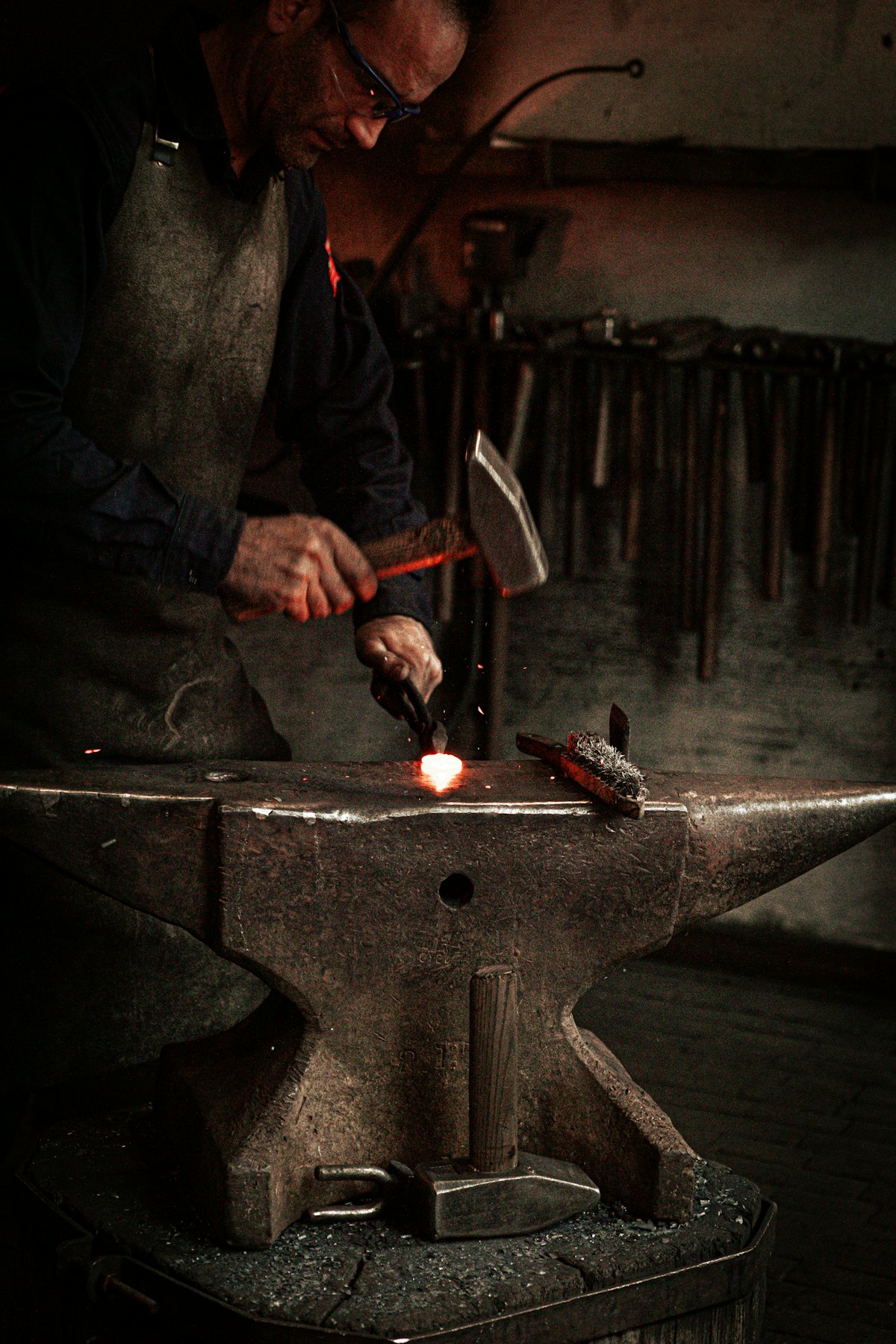 Blacksmith hammering glowing hot metal on an anvil