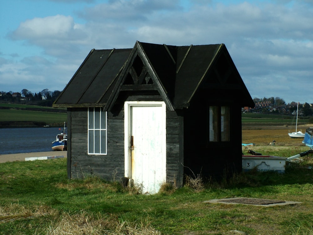a small black shed with a white door