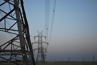 power lines in a field with a blue sky in the background