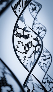 A caring female geneticist consulting with a patient online, with DNA helix graphics in the background.