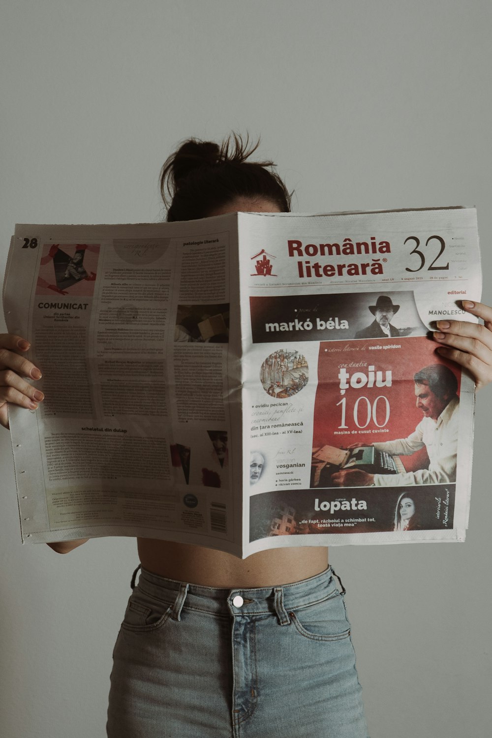 Una mujer sostiene un montón de periódicos