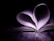 A book with its pages curved inward, forming the shape of a heart. The surrounding is dark, while the pages are illuminated by soft light, emphasizing the heart shape.