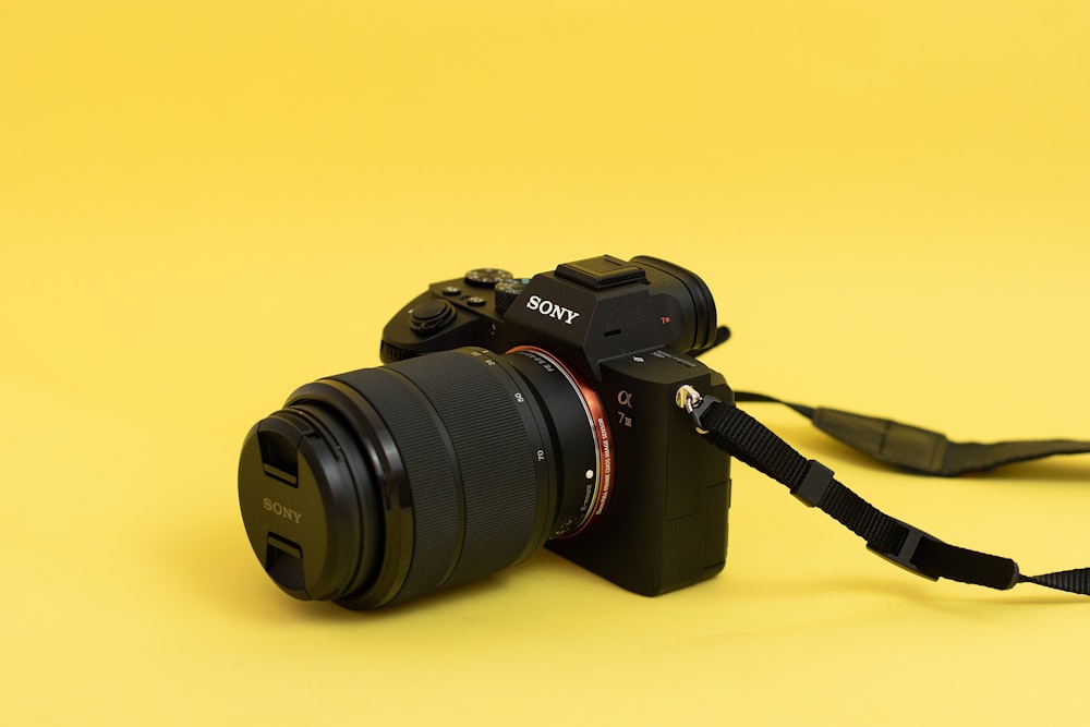 a camera on a yellow background with a black strap