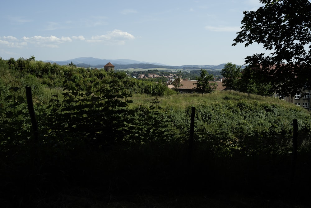 a field with a fence and a building in the distance