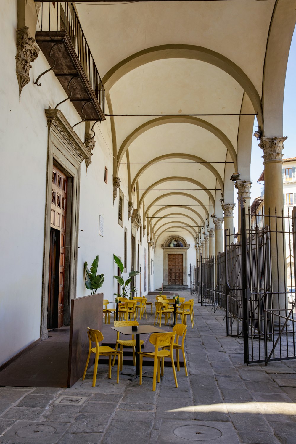 a row of yellow chairs sitting on top of a sidewalk