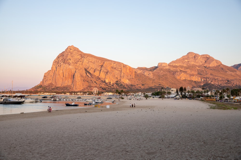 a beach with boats and mountains in the background