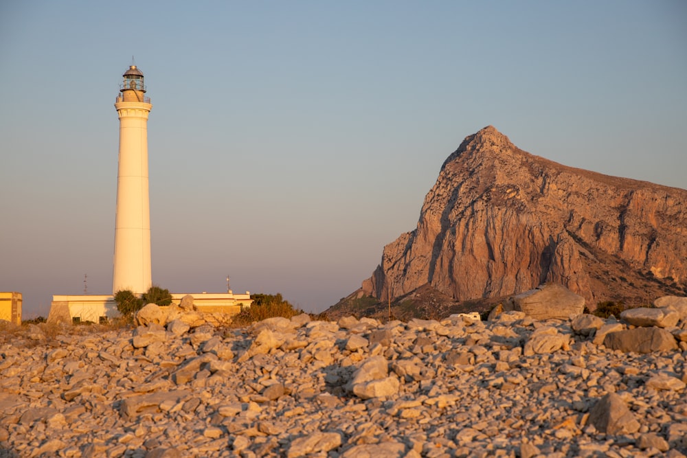 Un faro seduto sulla cima di una collina rocciosa