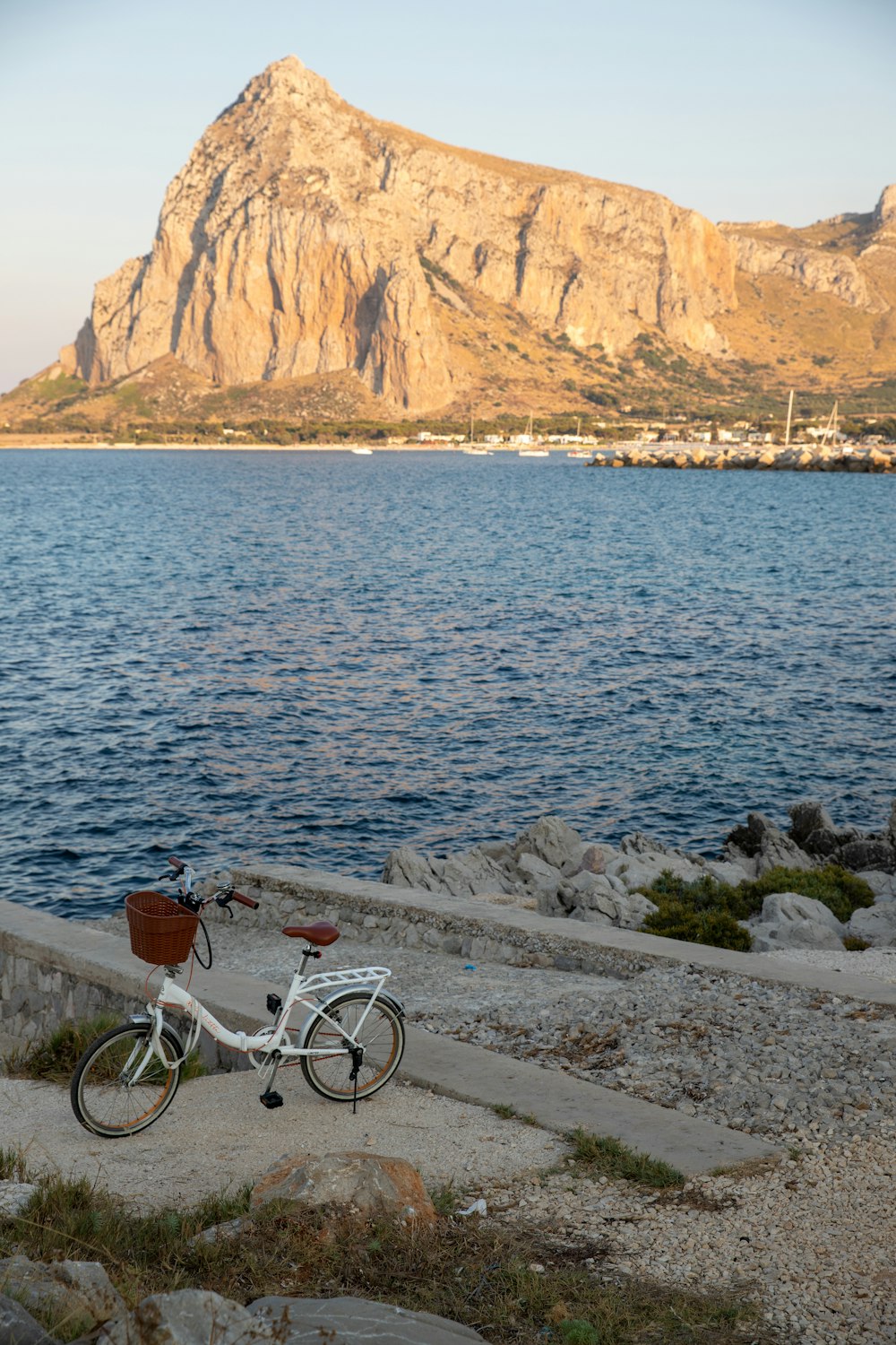 a bike parked on the side of a road next to a body of water