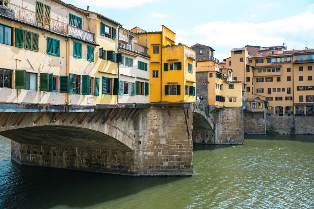 a bridge over a body of water with buildings in the background