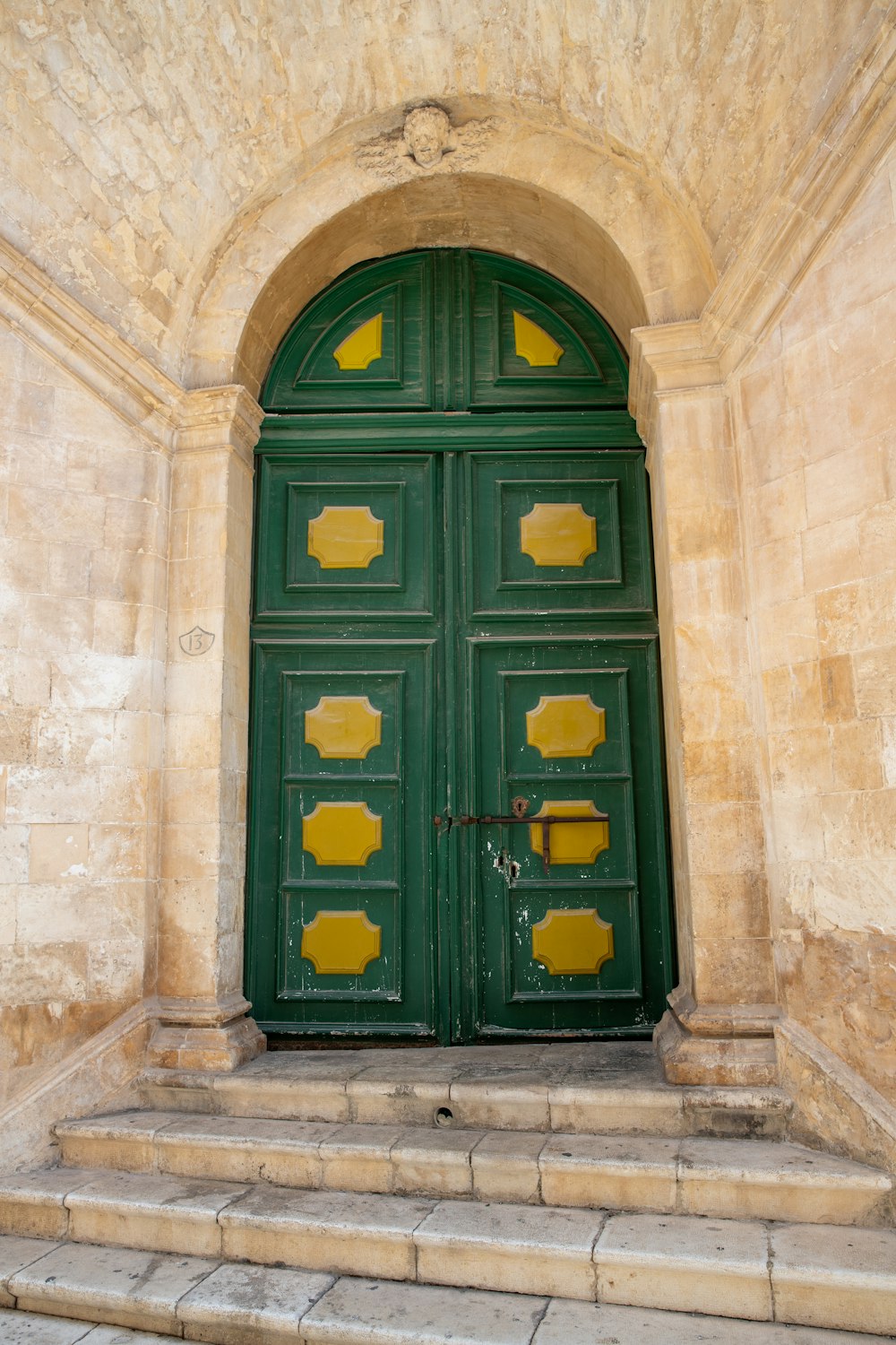 a green door with yellow paint on it